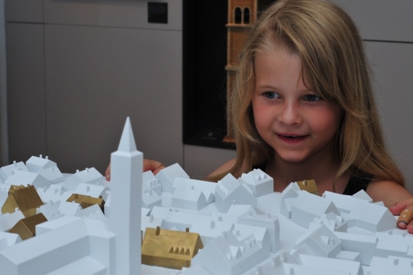 Ein Mädchen betrachtet staunend das Friedberger Stadtmodell im Museums