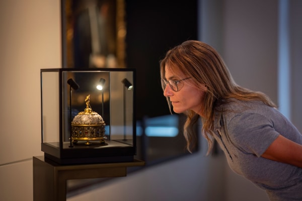 Besucherin betrachtet Tischuhr im Museum im Wittelsbacher Schloss Friedberg, Foto: Norbert Liesz